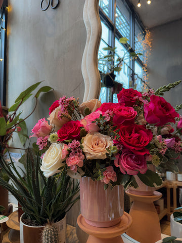 Pink and red rose flower arrangement in a glazed vase